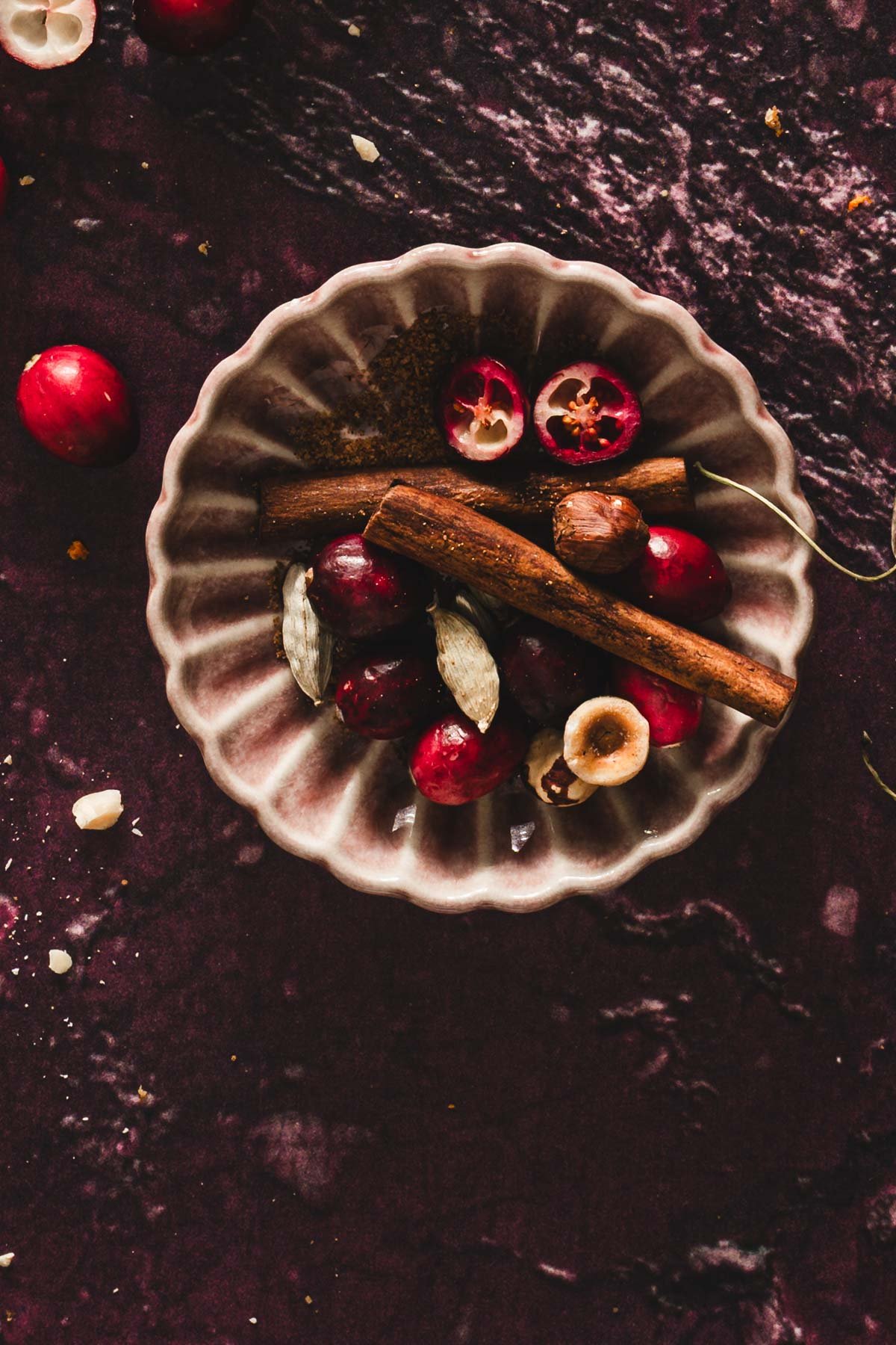 small dish with freshcranberries, cinnamon stick